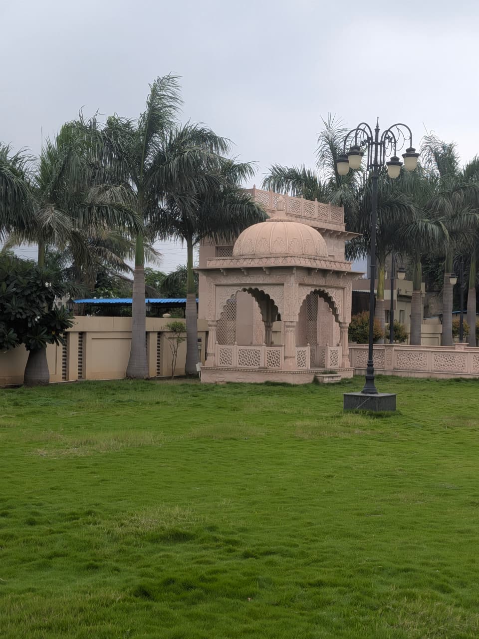 Rajasthani style carved dome pavilion surrounded by palms at The Royal Courtyard